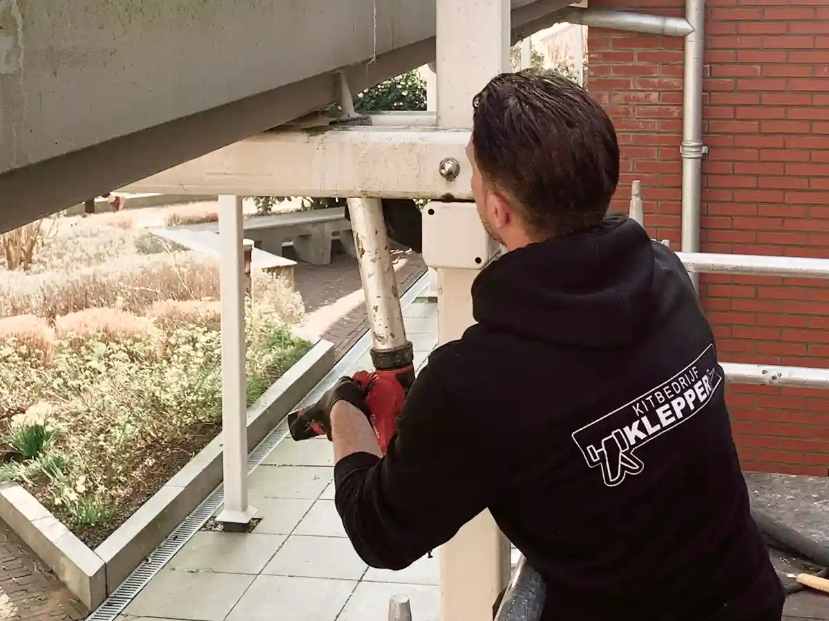 Vakman voert kitwerk uit aan buitengevel met kitspuit
